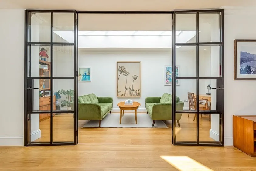 Glazed internal doors linking a completed extension to the hallway and staircase