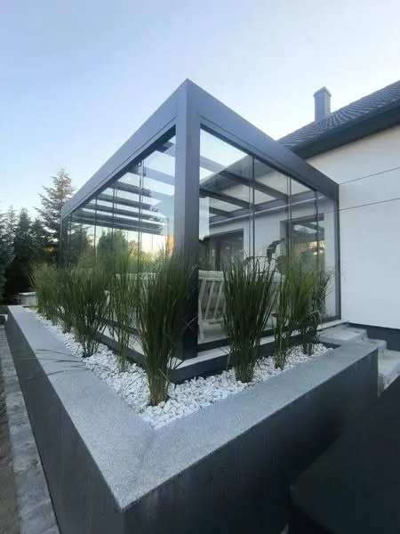 Freestanding glass and aluminium pergola in a landscaped garden