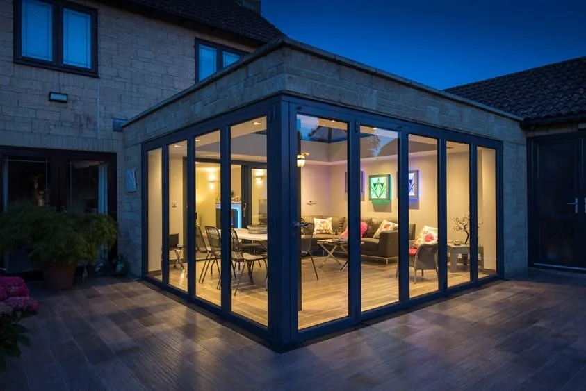 Side extension lit at night with folding glazed doors