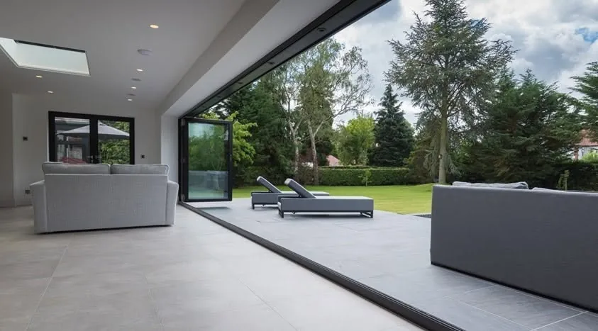 Living space opening onto a patio through full width sliding doors
