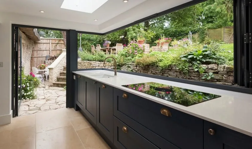 Navy shaker kitchen with bi-fold doors opening to the garden